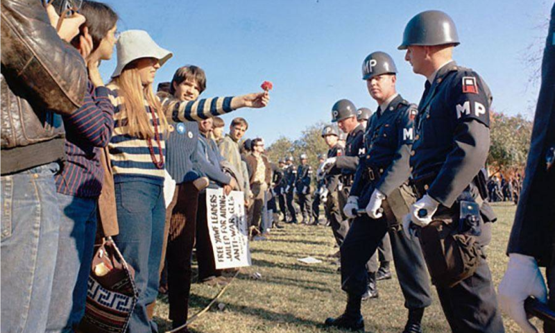 Um manifestante oferece uma flor a um policial militar durante um protesto contra a guerra do Vietnã no Pentágono.Wikimedia Commons